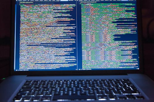 Laptop displaying source code with dual screens for software development.